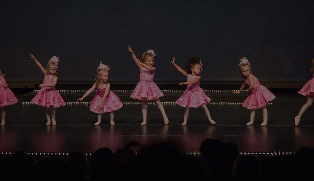 little girls performing a ballet performance in pink tutus