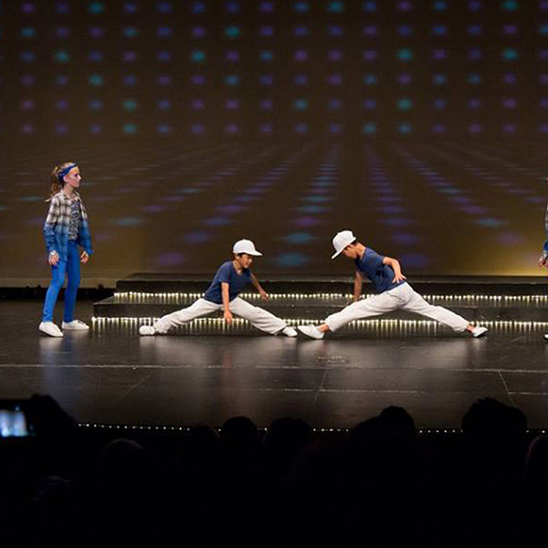 young students performing a hip hop routine where two boys do the splits